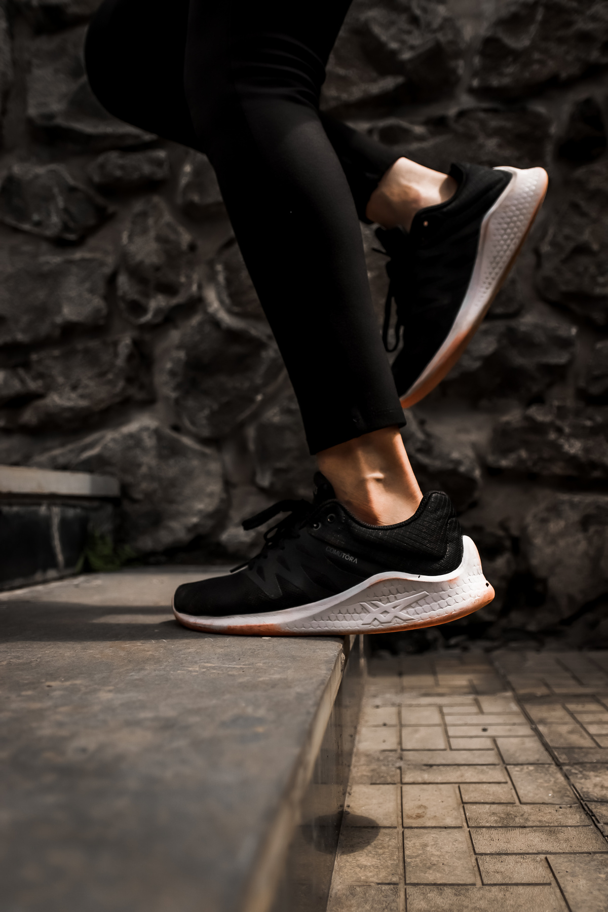 Faceless athlete running on steps in street